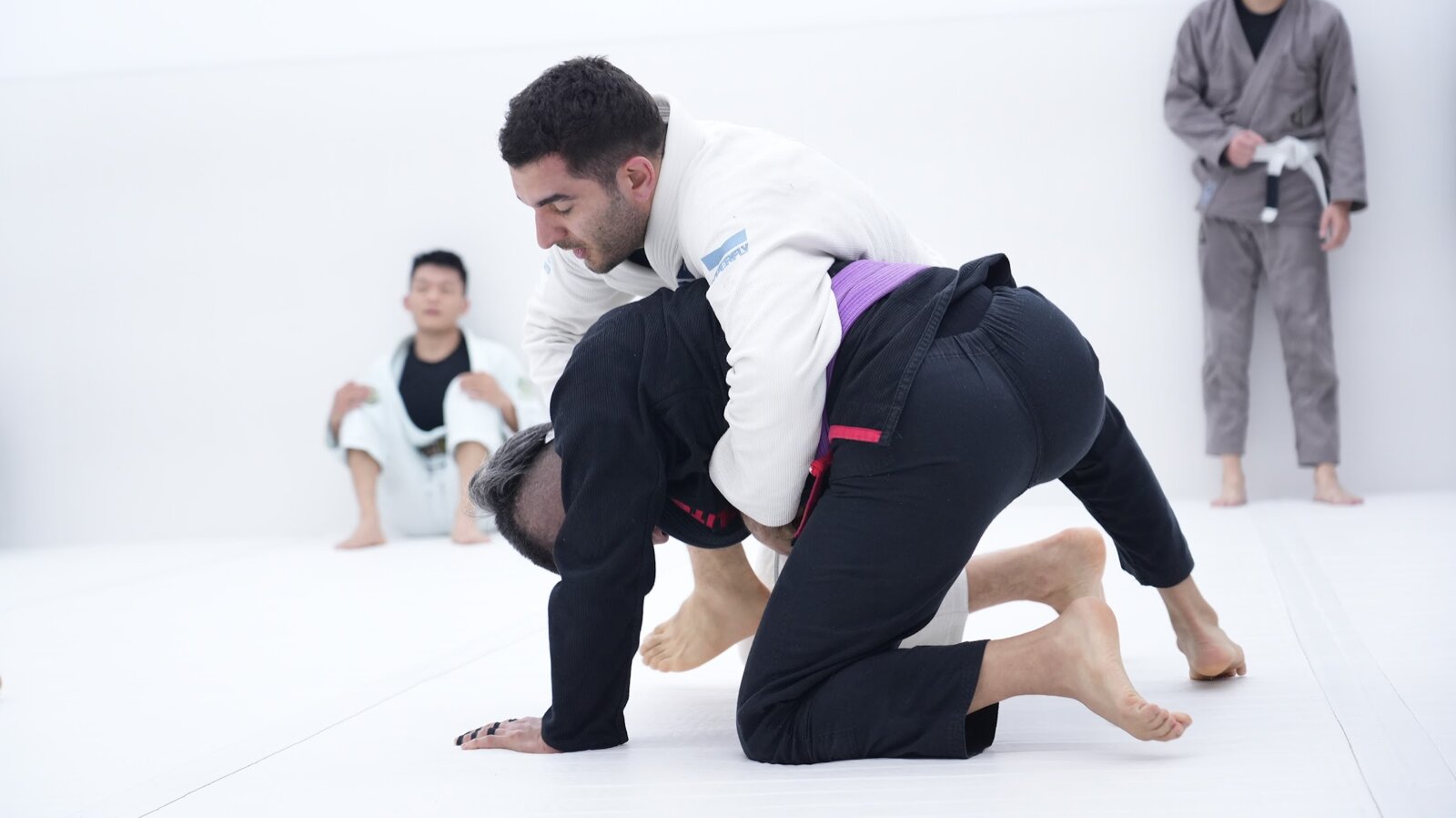 Training jiu jitsu with a training partner on the mats