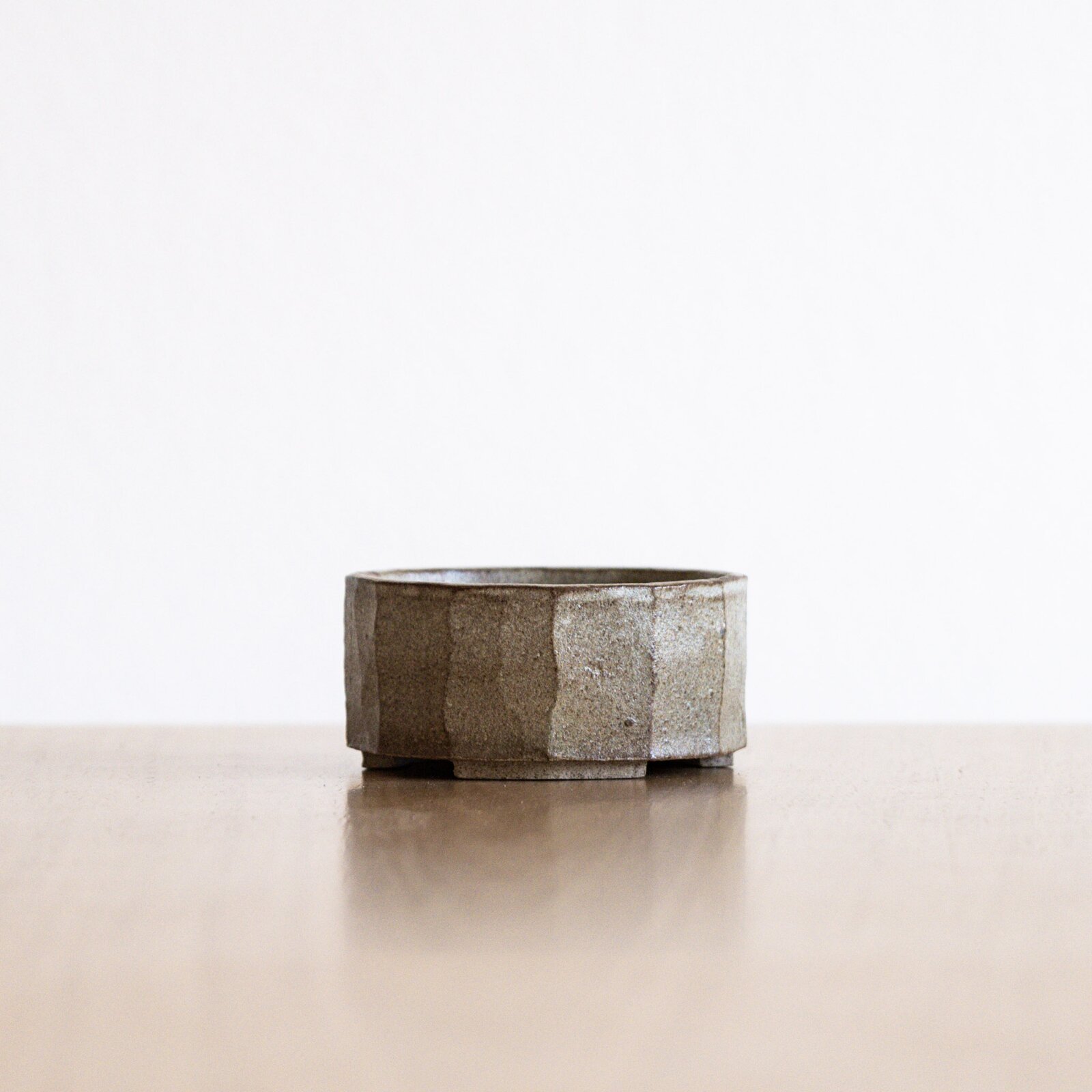 A handmade ceramic bonsai pot with a blue speckled glaze